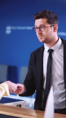 Videoda takım elbiseli profesyonel bir adam var. Telefonunu kontrol ediyor. Kendine güvenen bir konuşma yapıyor.