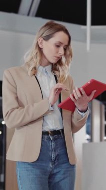 Güzel, genç, beyaz, sarışın, patron. Ofis Kabinesine doğru gidiyor. Tablet Bilgisayar Şirketler Koridorunda yürüyor..