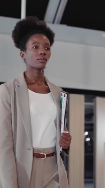 Tablet cihazlı Afro-Amerikan genç bayan modern şirket koridorunda iş toplantısına gidiyor..