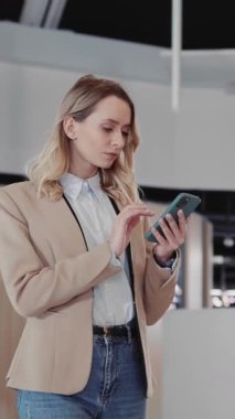 Sarışın Zeki Genç Kadın Girişimci Akıllı Telefon Onollü İnternet Uygulamasını Kurumsal Ofiste Yürümeye Gidiyor.