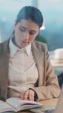 Yaratıcı Ofis Kuruluşunda Bilgisayar Dizüstü Bilgisayarı Tasarım Projesini kullanarak Masa Yönetimi Yönetiminde Genç Güzel Resmi Kadın Yöneticisi.