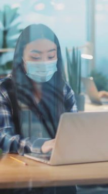 Karantina sırasında şirket şirketinde çalışan tıbbi maske takan Asyalı genç bayan çalışanlar. Sağlık hizmetleri. Koronavirüsü kilitleyin..