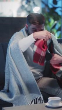 İnsanlar, sağlık hizmetleri, salgın hastalık konsepti. Akşamları evde kalıp battaniyeye sarılarak ısınan beyaz iş adamı hapşırma alerjisi kötü hissettiriyor..