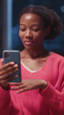 Genç Afro-Amerikalı kadın akıllı telefon çağrı video kasetine katılıyor. Annemle uzaktan iletişim kuruyor ve yeni modern dairesinde kalıyor. Bağlantılar.