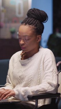 Bu videoda beyaz kazaklı bir kadın dizüstü bilgisayar kullanıyor ve çeşitli ortamlarda teknolojiyle uyum ve neşesini gösteriyor.