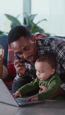 Genç baba ve küçük bebek bedeninin mutlu aile portresi dizüstü bilgisayar kullanarak evde eğitim için komik oyunlar oynuyor..