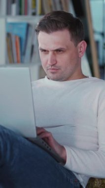 Çekici, genç, serbest çalışan, uzak bir projeyi dizüstü bilgisayarla yapıyor oturma odasında dinleniyor. Öğleden sonra işi. Karantina.