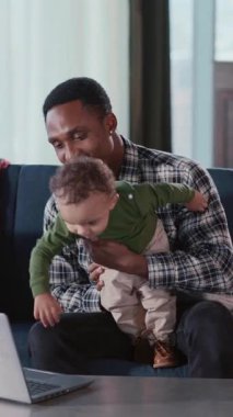 Genç, yakışıklı, neşeli baba, küçük oğlana bakıcılık yapıyor, evde vakit geçiriyor. Babam serbest çalışıyor ve oğluyla ilgileniyor..