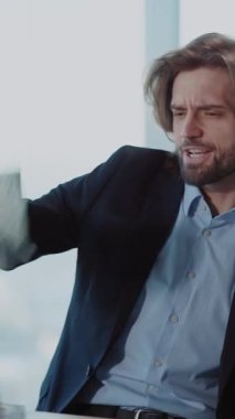 Videoda para hayranını gösteren takım elbiseli sakallı bir adam var. Başarısını ve finansal hünerini vurgulayarak zenginliği vurguluyor.