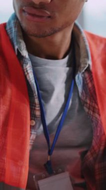 Afrika 'lı genç erkek tasarımcının ofis içi kalem çizimi için bina planı planlarken yakın plan görüntüleri. Güvenlik yeleği. Mimar konsepti.