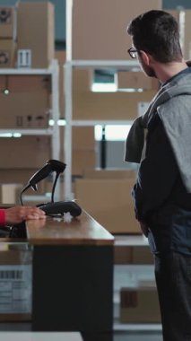 Kafkasyalı müşterilere hizmet eden Afrikalı genç, kibar bayan çalışanlar karton karton paket teslimat kutusunun alınması için ödeme yapıyorlar..