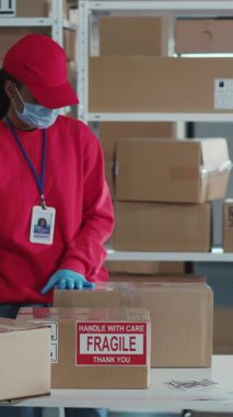 Posta Ofisinde Maskeli Genç İşçilerin Çoklu Etnik Çifti Pandemik Coronavirus Karantinası 'nda İletişim ve Paketleme Kutuları Giyiyor.