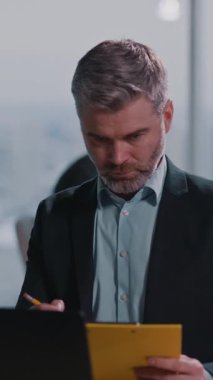 Masasında takım elbiseli kendine güvenen bir işadamı bir tablet kullanıyor, profesyonellerin teknolojiye güvendiğini gösteriyor ve iletişimi güçlendiriyor, yoldaşlığı vurguluyor.