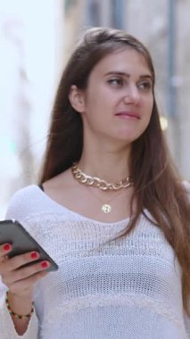 Eski sinema şehrinde sokakta yürürken akıllı telefon uygulaması kullanan neşeli beyaz bir bayan. Turizm konsepti. Hırvatistan ve Avrupa 'ya Seyahat.