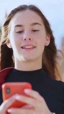 Güzel sahilleri keşfetmek için akıllı telefondan navigasyon kullanan çekici, genç, modern bir kadın turist. Telefonu olan insanlar. Şık kız..