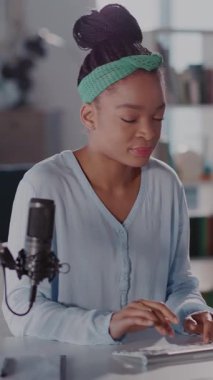 Bu video, masa başında çalışan, daktilo eden, telefon kullanan, mikrofona konuşan, modern iletişimi gösteren odaklanmış bir kadını gösteriyor.