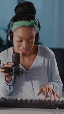 Bu videoda rahat stüdyosunda yetenekli bir kadın var. Klavye çalıyor ve bir şarkı kaydediyor. Müzikal yaratıcılığını ve tutkusunu sergiliyor.