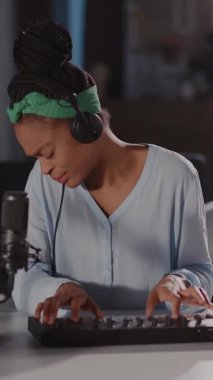 Bu videoda, yaratıcılığa kendini kaptırmış yetenekli bir kadın, odaklanmış performansını ve sanatsal sürecini gösteren, kulaklıkla klavyeyi ustaca çalıyor.