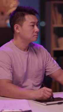 Mor gömlekli bir adam elinde bir not panosu ve kalemle masada oturuyor ve bilgileri inceliyor. Bazen kameraya hitap etmek için kafasını kaldırır.