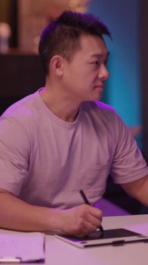 Mor gömlekli bir adam bir tablete notlar alır, odaklanmış bir şekilde. Sahne pembe tişörtlü bir adama dönüşüyor. Gülümseyen ilk adam sıcak bir sonuç çıkarıyor.