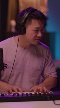 Bu video, stüdyoda klavye çalan, şarkı söyleyen, gülümseyen ve pozitif enerjiyi paylaşan bir müzisyeni gösteriyor.