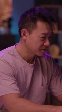 Bu videoda, mor gömlekli bir adam dizüstü bilgisayarda çalışıyor, konsantrasyon ve rahatlama gösteriyor. Pembe gömlekli bir adamla kameraya bakıp gülümsüyor ve neşeli bir atmosfer yaratıyor.