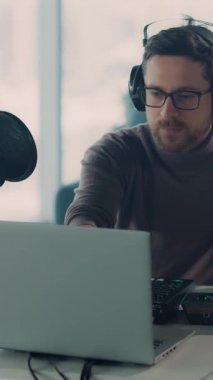 Bu videoda, kulaklık ve gözlük takan genç bir adam laptopuyla tutkuyla etkileşime geçiyor, mikrofona şarkı söylüyor ve müzik yeteneğini sergiliyor.