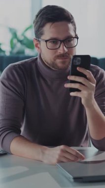 Masadaki bir adam cep telefonuna dalmış durumda. Bu da önemli bir konuşmanın içinde olduğunu gösteriyor. Dijital dünyadaki modern yalnızlığı yansıtıyor.