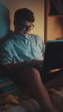 Videoda, gözlüklü, dizüstü bilgisayarına odaklanmış, sessiz bir alanda samimiyet ve konsantrasyon taşıyan genç bir adam görülüyor.