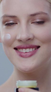 Cildine krem süren bir kadının yakın çekimi, sağlık ve güzellik hizmetlerine olan bağlılığını vurguluyor.