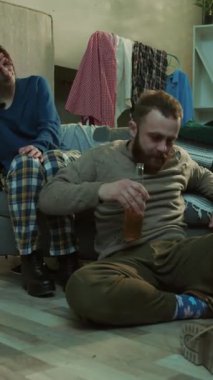 Üzgün genç bir kadın, alkolik bir adamın yanında oturuyor bira tutuyor stresli, alkolik, ürkek, umutsuz, mutsuz, yetişkin alkolizmi sorunu üzgün, üzgün, keyifli, yavaş çekimde, yakın çekimde portreyi çekiyor.