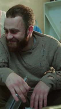 Sakallı, kadın ve bira içen alkolik adam kanepeye oturup konuşur. Stres, stres, korkunç ev, depresyon, mutsuz alkolizm sorunu. Yorgun, yavaş çekimde portreyi yakından çeker.