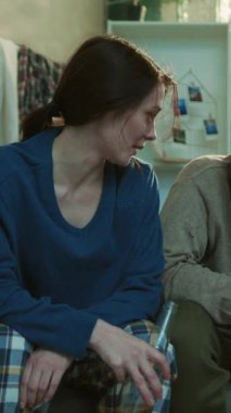 Gülümseyen alkolik genç çift bira içiyor. Kanepede oturuyor. Stres, sağlıksız, ürkünç, umutsuz, mutsuz, yetişkin alkolizmi sorunu.