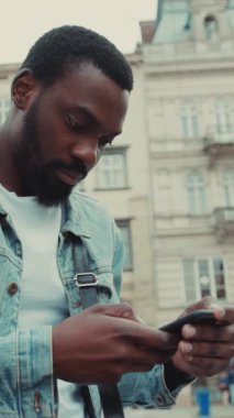 Hayat dolu, hareketli bir şehir ortamında akıllı telefonunu kullanan şık bir adam.