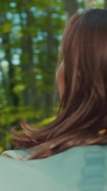 Dönüşümlü olarak gülümseyen çekici bir kadının yeşil ormanın güzelliğini gözlemlemesi. Doğal güzellik, tazelik, rahatlama. Kadın portresi