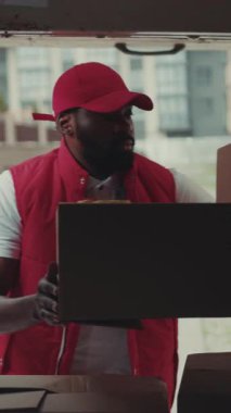 Yakışıklı kurye genç Afro-Amerikan adam kutuları arabaya koydu teslimat işi posta üniforması taşıdı güçlü taşıma paketi servisi yetişkin yakın çekim portre koordinasyonu yavaş çekim