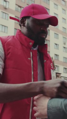 Yüz kuryesi Afro-Amerikan, teslimat cihazı karton teknoloji kutusunu imzaladıktan sonra posta kutusu siparişi verdi.