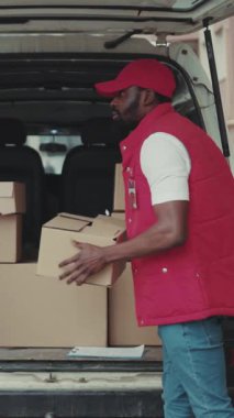 Kurye Afrikalı Amerikalı, posta kutusunun yanındaki dağıtım cihazını imzaladıktan sonra posta kutusu siparişi verdi. Postacı sakallı, lojistik postacı.