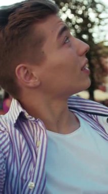 Portre çekici genç adam kameraya bak gülümse konuş açık havada mutlu ol çocuk yavaş çekim yaşam tarzı Kafkasyalı neşeli çocuk yavaş çekim moda öğrencisi