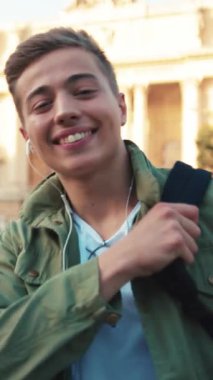 Kulaklık takmış genç bir portre. Kameraya bak. Gülümse. Sokakta mutlu ol.