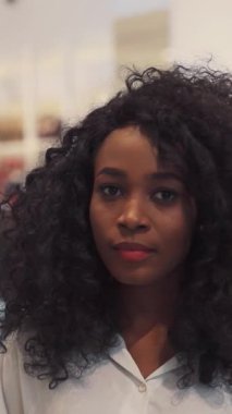 Şehvetli ve güzel kıvırcık saçlarını gururla gösteren bir kadının çarpıcı ve samimi bir fotoğrafı.