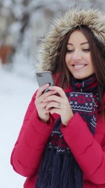 Parlak kırmızı ceketli ve eşarplı bir kadın, karlı bir arazide telefonunda kayboluyor. Huzurlu bir kar yağışı ortasında rahat bir hava yaratıyor.