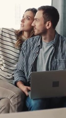 Bir erkek ve kadın kanepede dizüstü bilgisayarla oturup ortak meraklarını ve bağlantılarını vurgulayan ortak bir oturumla meşgul olurlar.