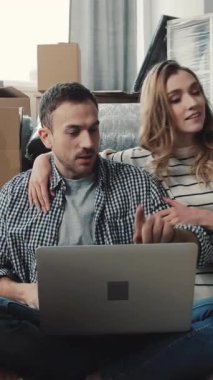 Bir erkek ve bir kadın yerde oturup, bir dizüstü bilgisayarın içeriğini tartışarak, dost canlısı köpekleri ile birlikte, sıcak bir atmosfer yaratıyorlar.