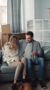 Oturma odasındaki bir çift yeni evlerinin anahtarlarına sahip. Umudu ve yeni başlangıçları sembolize ediyorlar. Gülümsemeleri, el ele tutuşmaları ve sarılmaları paylaşıyorlar.