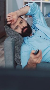 Sakallı bir adam evinde rahat bir gün geçirir, uzaktan kumandayla kanepeye uzanır, sonra da telefonunu dinleyerek yerde oturur. Gelişigüzel giyinerek, modern rahatlığı somutlaştırıyor.