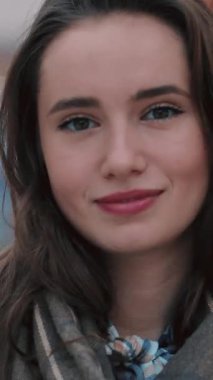 Genç bir kadın düşünceli bir şekilde profiline bakıyor, güzel bir şekilde etrafı ışıldayan ışıklarla çevrili.