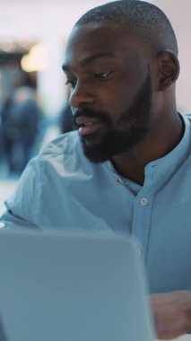 Kendini işine adamış bir profesyonel iyi tasarlanmış çağdaş bir ortamda dizüstü bilgisayarı üzerinde çalışırken son derece meşgul olur.