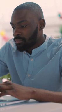 Işıkla dolu geniş ve modern bir çalışma alanında, odaklanmış bir birey özenle bir dizüstü bilgisayar kullanıyor.