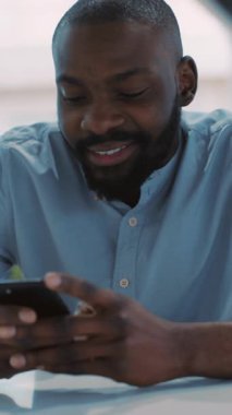 Odaklanmış bir birey, akıllı telefonunu parlak ve modern bir ofiste, üretkenliği ve bağlılığı sağlamak için kullanır.